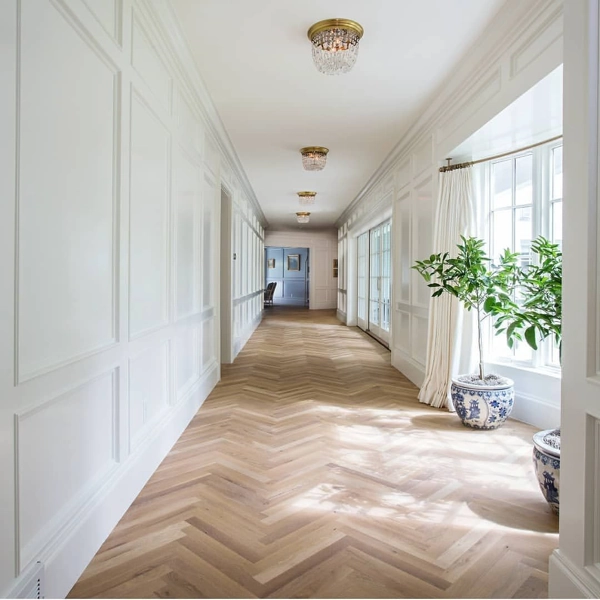 Light airy hallway with herringbone wood floors.
