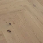 Light oak herringbone wood flooring with natural grain and knots