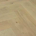 Light oak herringbone wood flooring with natural grain and knots