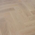 Light oak herringbone wood flooring with white-washed grain